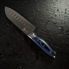 Couteau Santoku japonais, lame en acier damassé AUS-10, manche en G10 bleu, posé sur ardoise