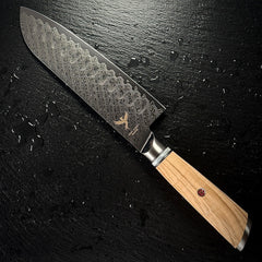 Couteau Santoku japonais, lame en acier damassé AUS-10, manche en résine et bois d'olivier, posé sur ardoise