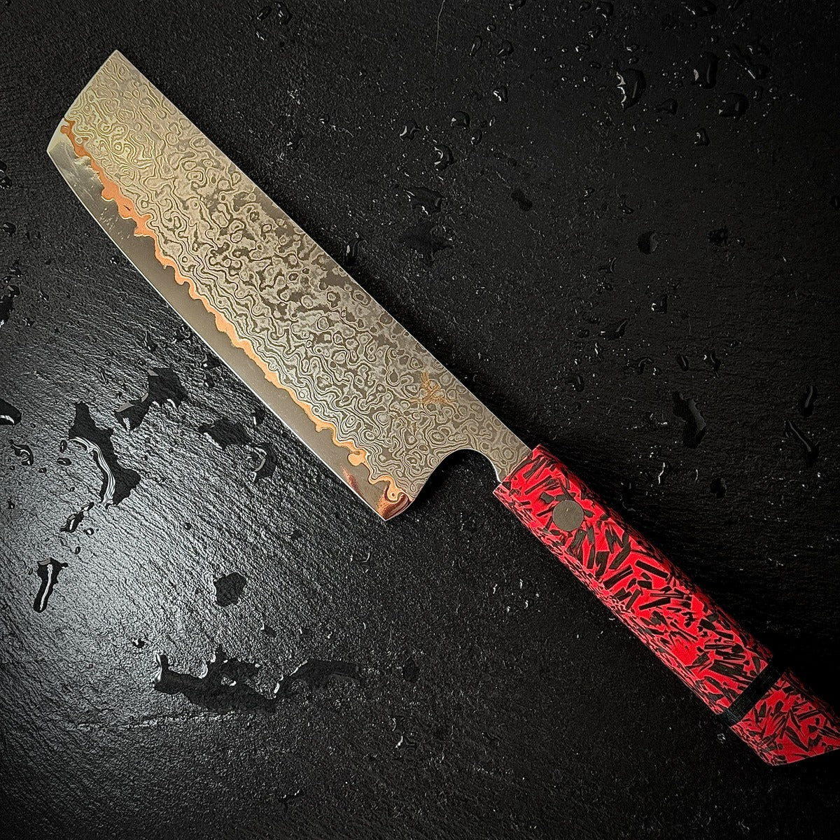 Couteau Nakiri japonais, lame en acier damassé 10Cr15CoMoV, manche en résine rouge, posé sur ardoise