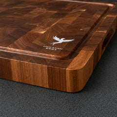 Grande planche à découper en acacia avec un couteau japonais posé dessus