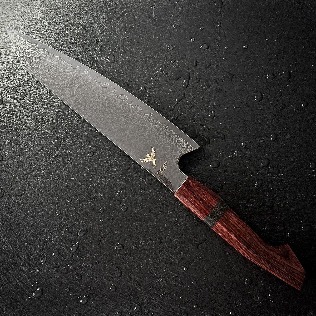 Couteau Kiritsuke japonais, lame en acier damassé 10Cr15CoMoV, manche en bois de santal, posé sur ardoise