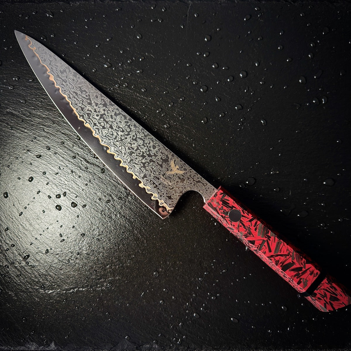 Couteau Gyuto japonais, lame en acier damassé 10Cr15CoMoV, manche en résine rouge, posé sur ardoise